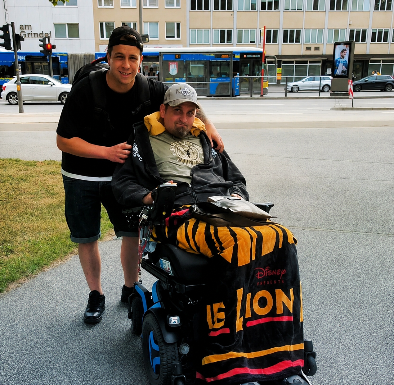 Moritz, Gründer von AssistMatch, mit seinem Onkel im Rollstuhl auf einem Gehweg